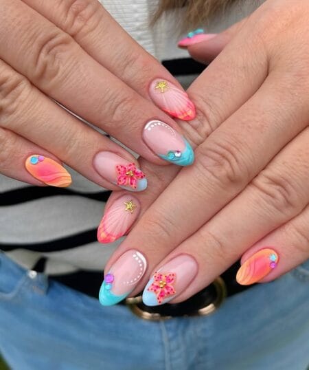 Tropical sunset almond nails with hibiscus charm starfish gold coral orange and blue French tip mix