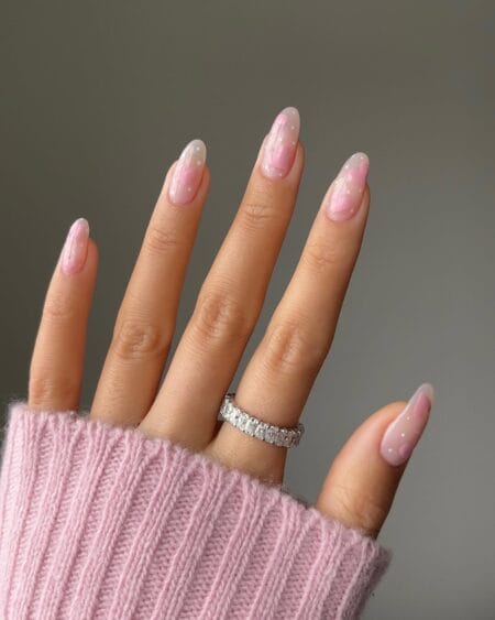 Sheer pink swirl and white polka dot nails with painted brushstroke detail on milky almond base
