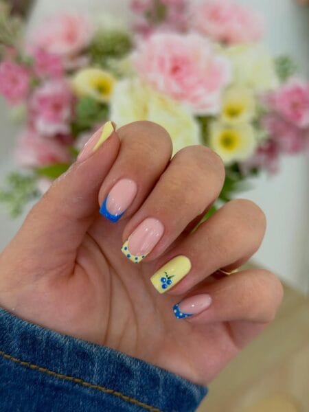 Butter yellow and cobalt blue polka dot nails with blueberry accent art on short square nails