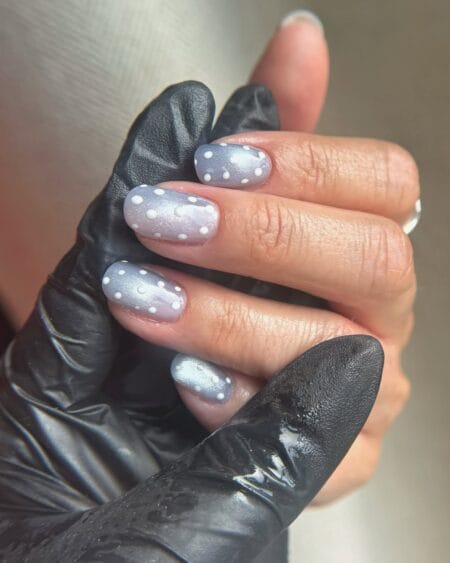 Lavender chrome polka dot nails with raised white dots on a shifting silver-purple base on short round nails