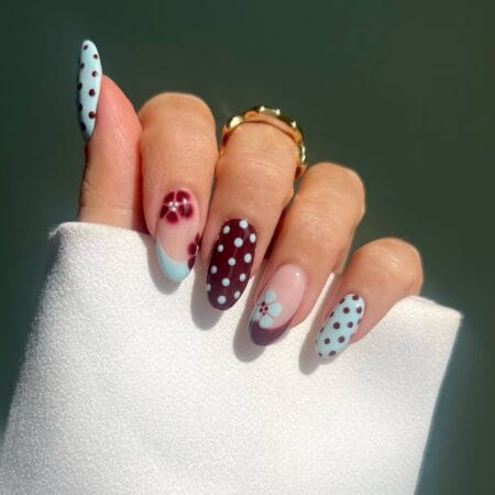 Mint and burgundy polka dot nails with floral dot accents and baby blue French tip on almond shape