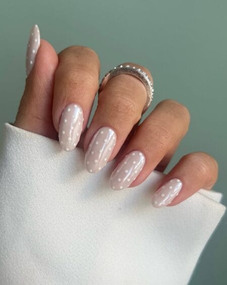 Cream pearl polka dot nails with iridescent finish and raised white dots on quiet luxury almond nails