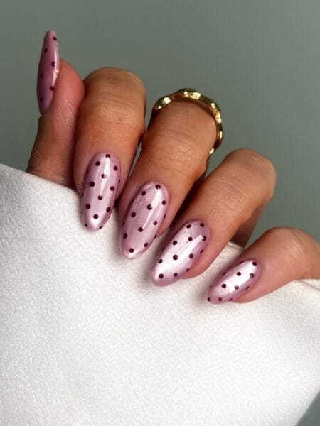 Rose chrome polka dot nails with burgundy dots on metallic pink shifting base on long almond nails