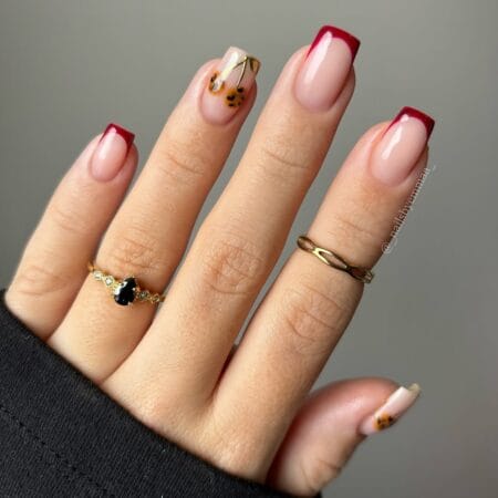 Maroon French tip nails with tortoiseshell and cherry accent for autumn