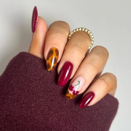 Maroon almond nails with tortoiseshell and cherry accents