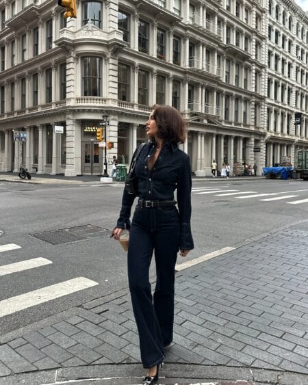 Woman in a dark indigo denim shirt and matching high-waisted flared jeans with patent heels