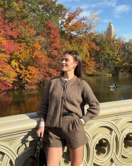 Woman in a chunky brown ribbed cardigan with matching brown wool tailored shorts on Bow Bridge