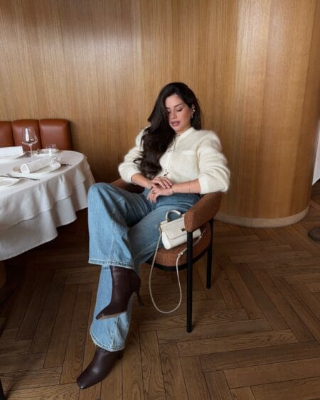 Woman in a cream mohair cardigan with light wash straight-leg jeans and chocolate ankle boots