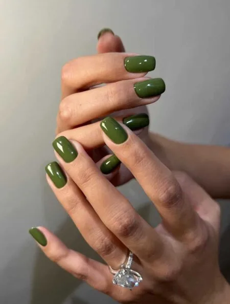 Olive green glossy nails with an earthy autumn-inspired finish.