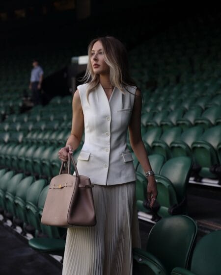 Cream sleeveless vest with pleated midi skirt for a chic Wimbledon look.