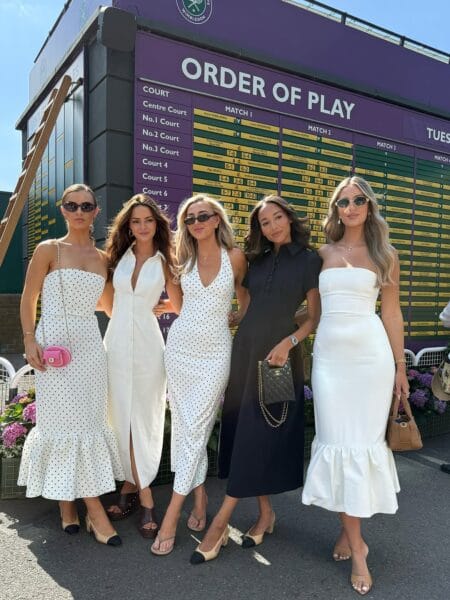 Group wearing coordinated white and black dresses for stylish Wimbledon outfits.