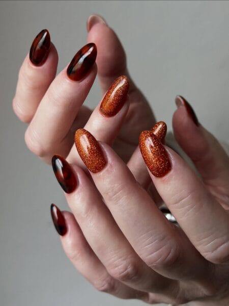 Burnt orange glossy nails in a warm pumpkin-inspired shade.