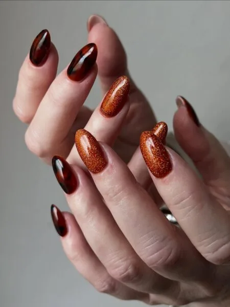 Burnt orange glossy nails in a warm pumpkin-inspired shade.