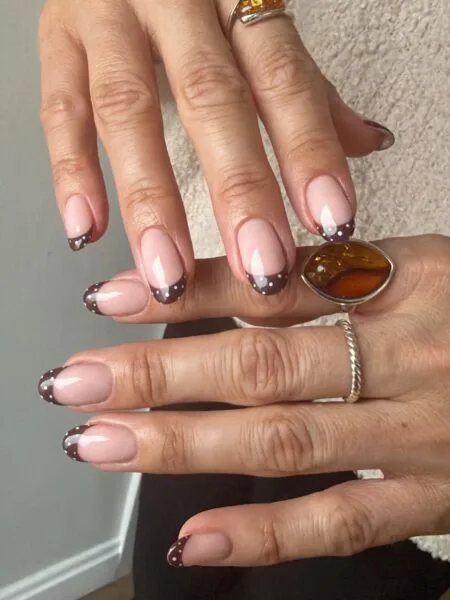 Nude nails with chocolate brown French tips.