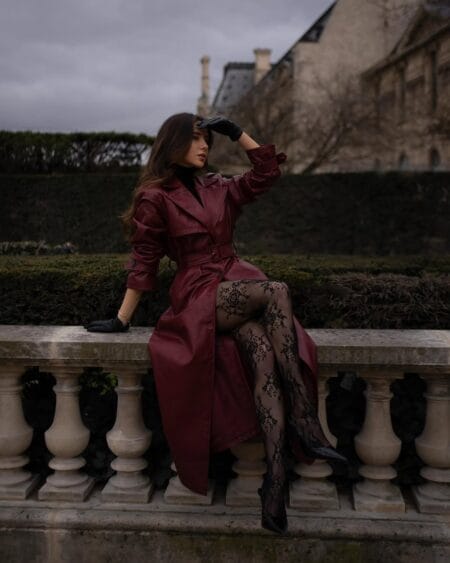 Burgundy leather trench with a black turtleneck and lace tights, a deep red fall outfit in Paris