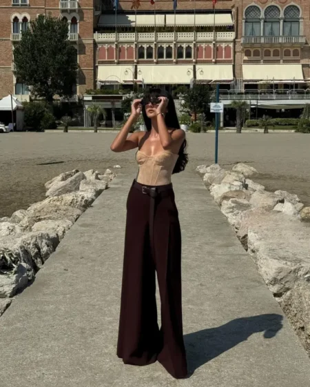 Nude corset top with deep burgundy wide-leg trousers, a transitional burgundy fall outfit