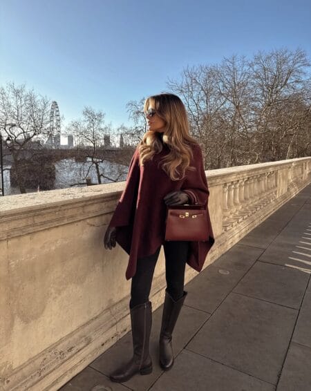 Burgundy wool cape with black leggings and knee-high boots, a deep red fall outfit