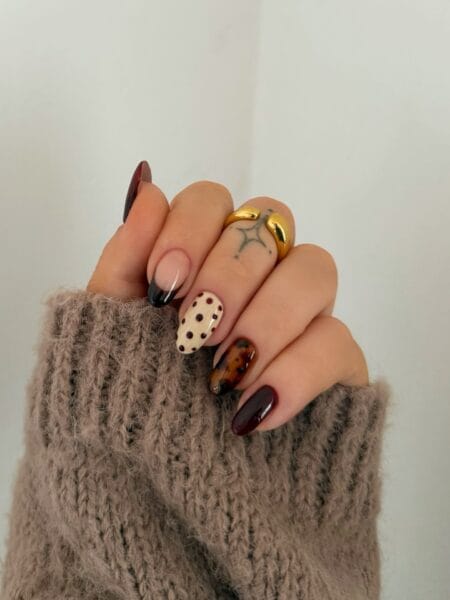 Almond-shaped tortoiseshell nails with amber and brown marbled details.