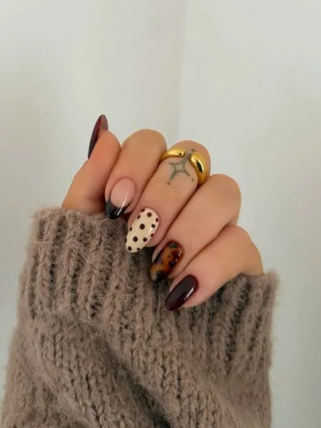 Almond-shaped tortoiseshell nails with amber and brown marbled details.