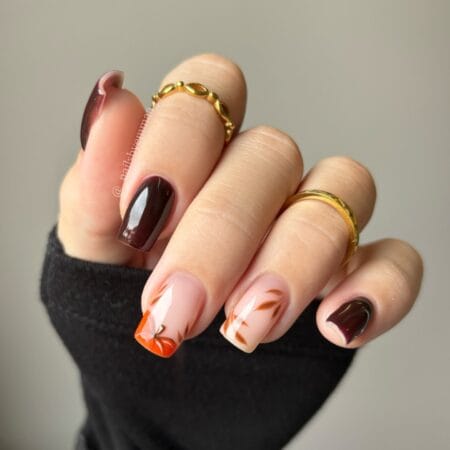 Oxblood and orange autumn nails with brown leaf French tips on short square nails