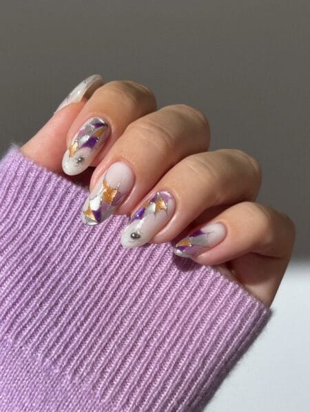 Sheer almond nails with purple and gold stained glass halloween nails
