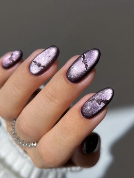 Lilac cat eye nails with tiny black bat silhouettes