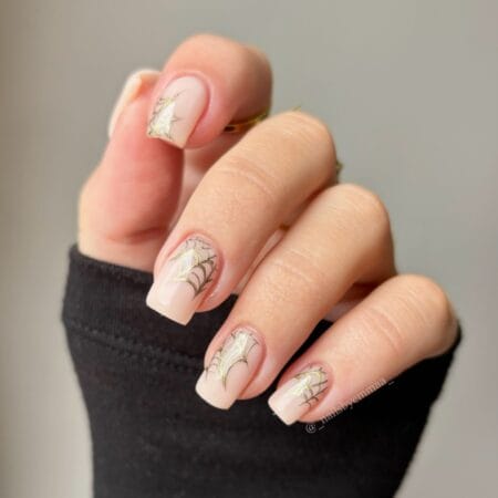 Sheer nude nails with metallic gold spider web halloween nails