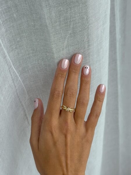 Pearl white nails with single tiny ghost accent