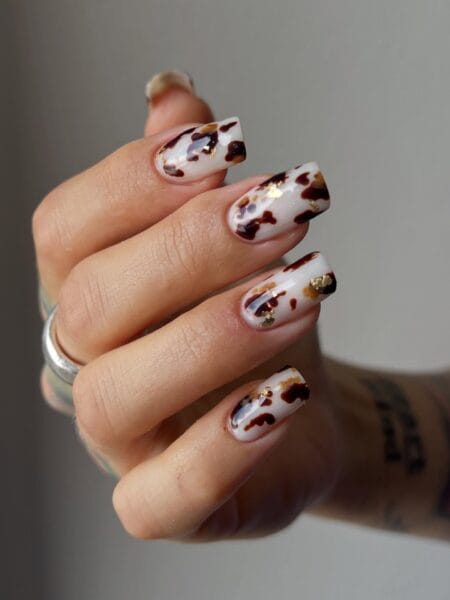 Milky white tortoiseshell nails with gold leaf flecks