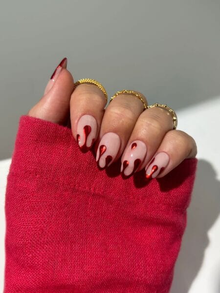 Nude almond nails with glossy red chrome blood drips