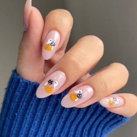 Long almond nails with painted ghosts pumpkins and mushrooms