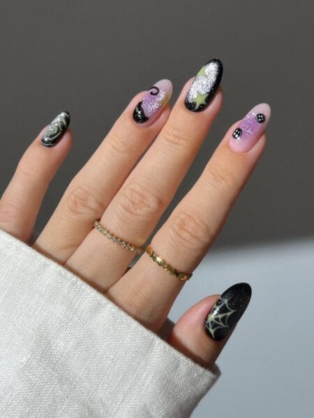 Almond nails with moons stars and spider webs witchy halloween nails