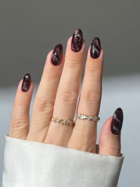 Smoky brown marble nails with elegant swirling details.