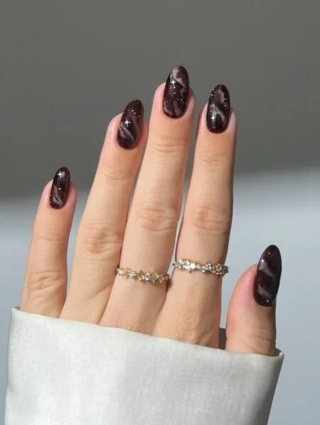 Smoky brown marble nails with elegant swirling details.
