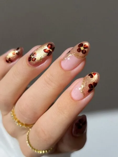 Nude nails with delicate gold foil accents.