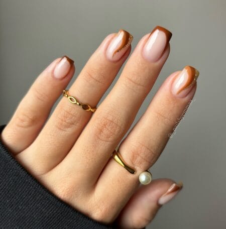 Nude nails with chocolate brown French tips.