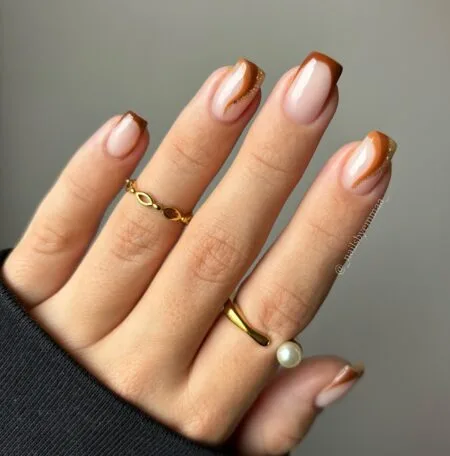 Nude nails with chocolate brown French tips.