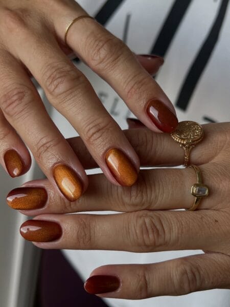 Short round nails in copper and rust cat eye polish