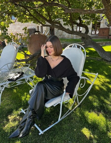 Autumn outfit with black off-shoulder knit, black leather midi skirt and tall boots