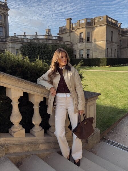 Old money fall outfit with cream leather field jacket, brown cable cardigan and cream jeans