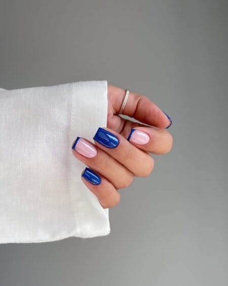 Short square nails with milky nude base and bold cobalt blue French tips