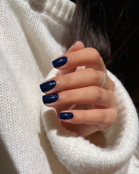 Deep navy blue short square nails in a glossy finish