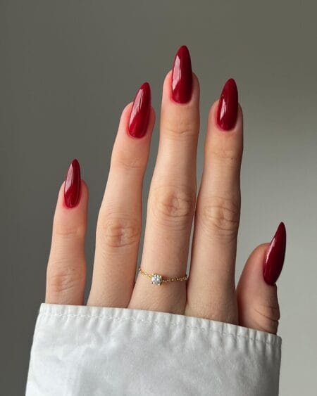 Long almond nails in true glossy red worn plain