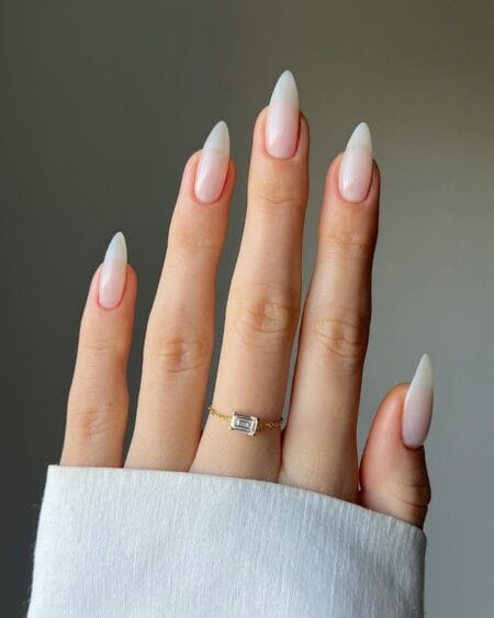 Long stiletto nails fading from soft pink to a milky white ombre tip