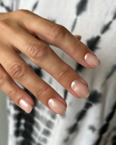 Short milky pearl nails with a soft iridescent shimmer on a rounded shape