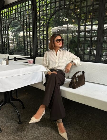 Striped linen shirt tucked into chocolate wide-leg trousers with cream pointed slingbacks