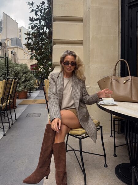 Check blazer styled with beige jumper, camel mini skirt and brown suede knee boots at a Paris café