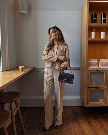 Cream tweed jacket with gold buttons worn over beige wide-leg trousers and two-tone flats