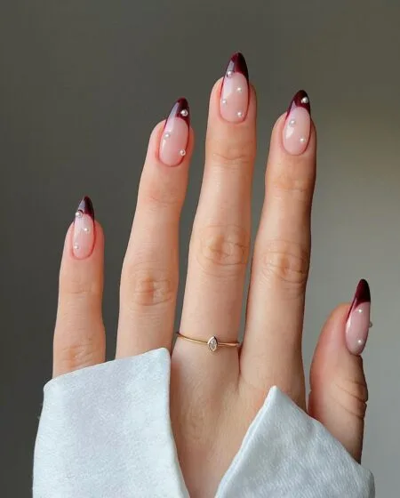 Dark cherry red nails with a glossy almond-shaped finish.