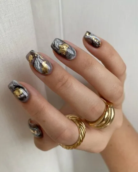 Nude nails with delicate gold foil accents.